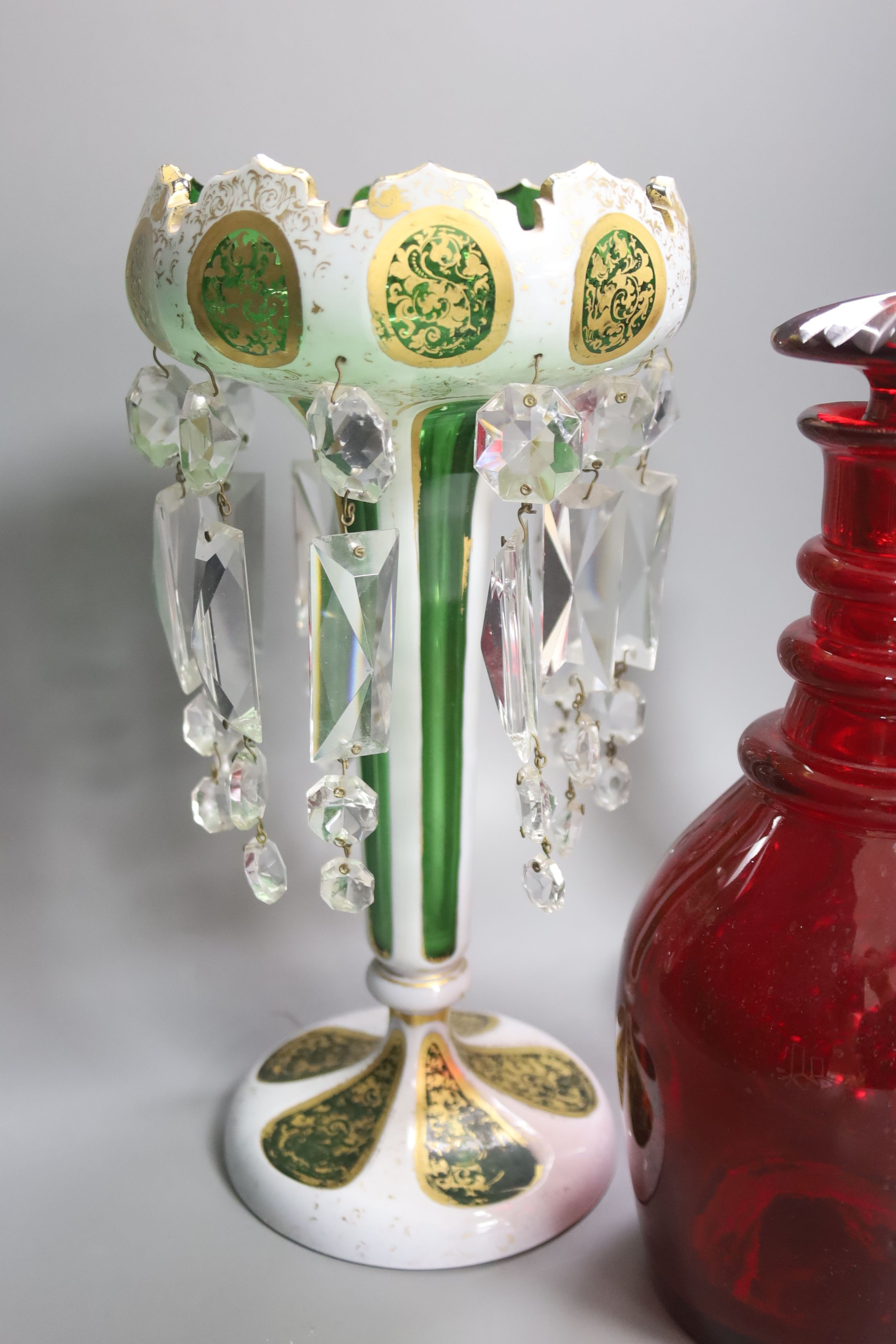 A rare ruby glass decanter circa 1830, a Bohemian overlaid glass table lustre and a cut clear glass ship's decanter, tallest 30cm